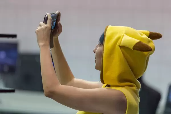 Cosplayerin und Pokemonfan im Pikachukostum auf der Gamescom in Köln