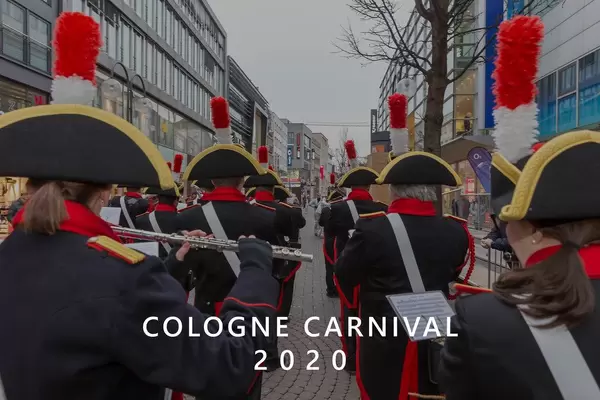 Costumed Marching band in uniform from behind during carnival Monday with the picture title "Cologne Carnival 2020"
