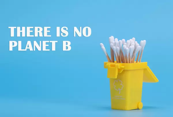 Cotton swabs in a trash can with There is no planet B text