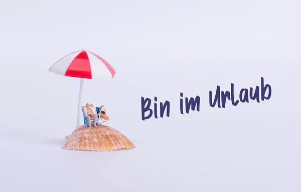 Couple sitting in deck chairs on sea shell with Bin im Urlaub text