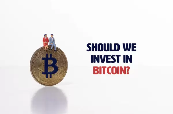 Couple  sitting on Bitcoin coin with Should we invest in Bitcoin text