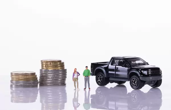 Couple with coin stacks and pickup truck on white background