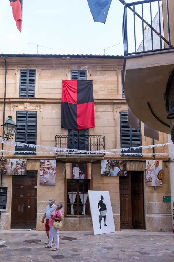 Couple with face mask, flags and Fotografik 31m photo exhibition. Summer event 2020 in Pollença