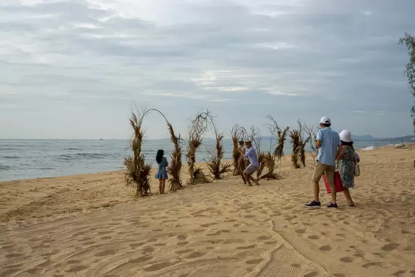 Couples taking Pictures at Plant Rings in the Sand at Sunset Sanato Beach Club in Phu Quoc, Vietnam
