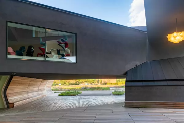 Courtyard of modern concrete interlaced Vitra building with a window revealing Panton chairs exhibition