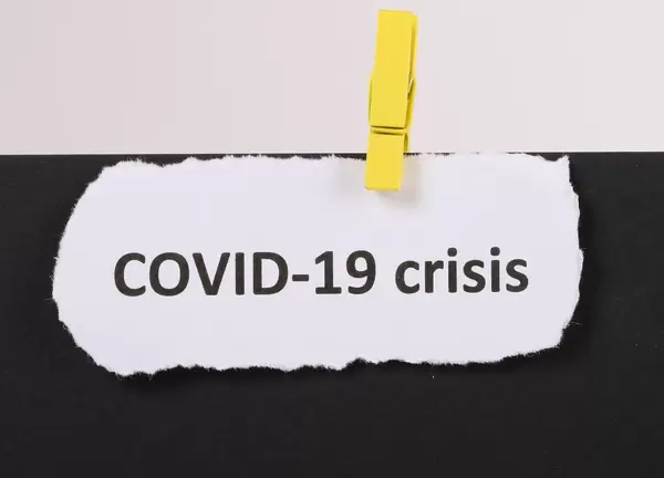 COVID-19 crisis text with yellow clothes spin