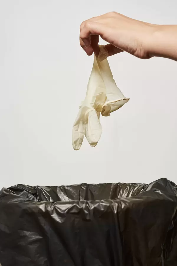 Covid-19 quarantine over - throwing medical gloves into the trash can