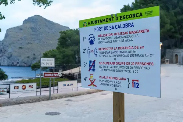 Covid-19 rules for visitors and locals in Mallorca, Spain explained on a sign in Port de Sa Calobra