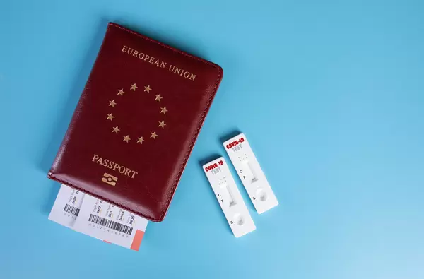 COVID-19 test cassette on passport on blue background