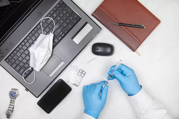 Covid-19 vaccination planning concept with doctor on the desk