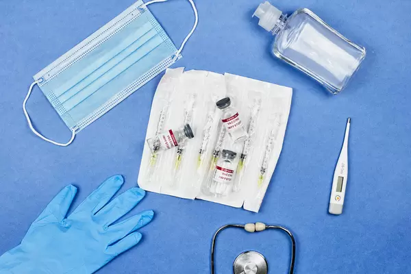 Covid-19 vaccine and the necessary equipment: syringes, face mask, glove, disinfectant, thermometer