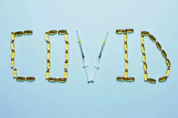 Covid text made with medical pills and syringes
