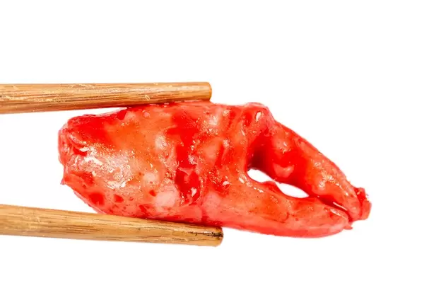 Crab claw marinated in red spicy sauce, close-up