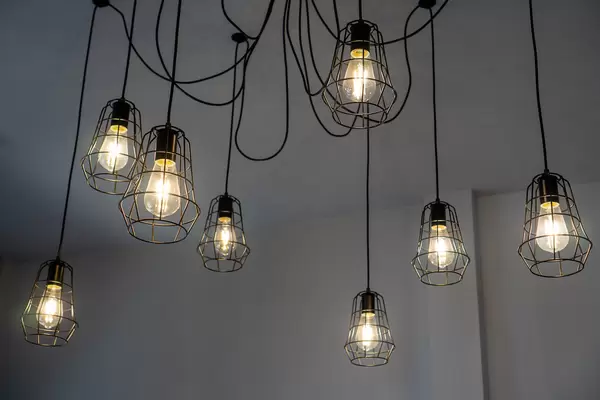 Creative and Decorative Hanging Ceiling Lamps with Bright Light Bulbs and Cables in a Cafe Seating Space