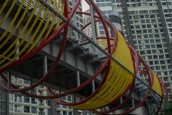 Creative Tube Pedestrian Bridge with Apartment Buildings in the Background at Vinhomes Central Park next to Vincom Landmark 81 Skyscraper in Saigon, Vietnam