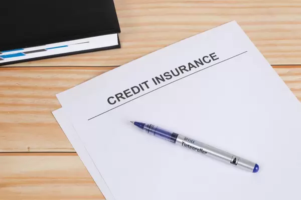 Credit Insurance text with pencil on wooden table