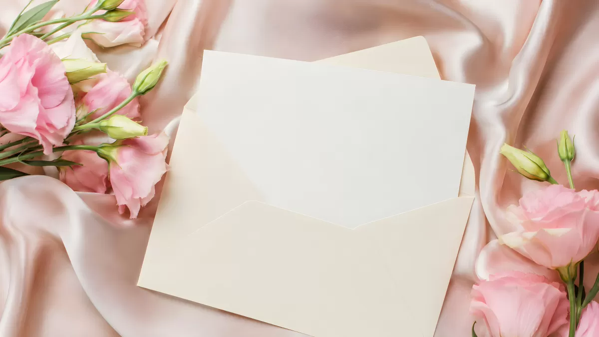 Cremefarbener Briefumschlag mit rosa Lisianthus auf Seide