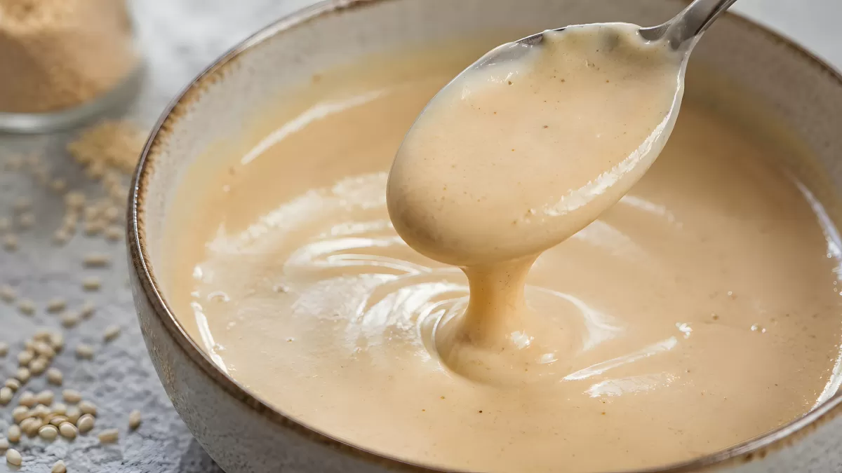 Cremige Tahini-Paste in Schüssel mit Löffel