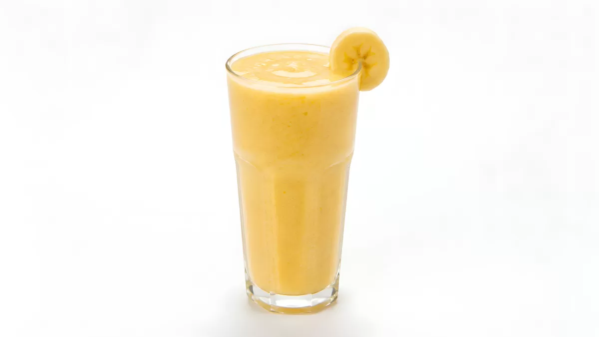 Cremiger Bananen-Smoothie im hohen Glas mit Garnitur