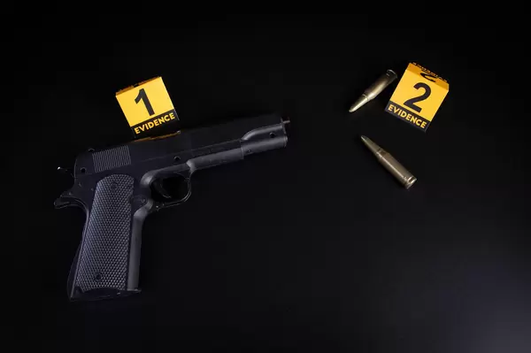 Crime scene concept with a gun and evidence markers