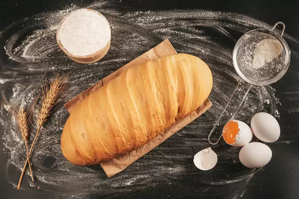 Crispy corn loaf on a dark table with ingredients