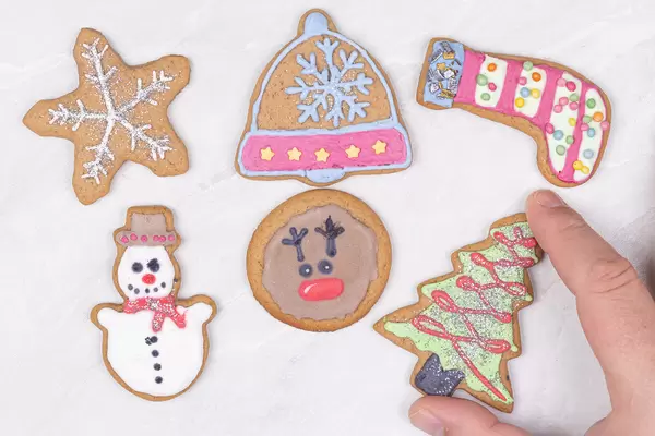 Cristmas Cookies on the table with hand holding Cristmas Tree