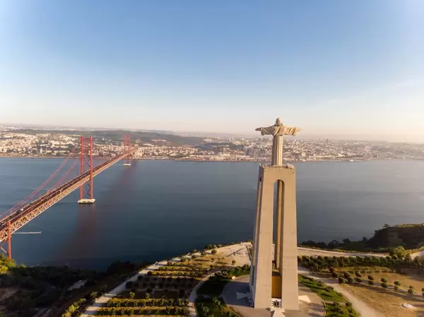 Cristo Rei Statue von hinten mit Ponte 25 de abril Brücke in Almada Lissabon