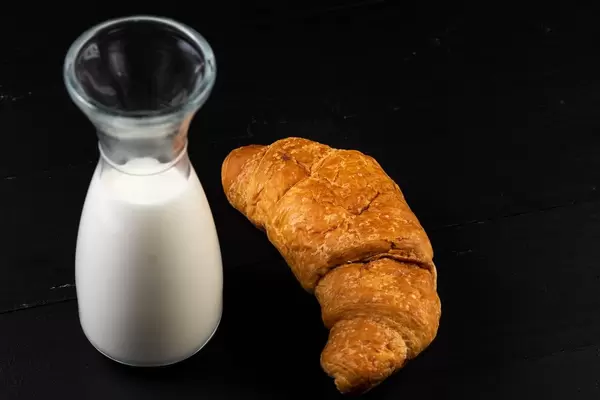 Croissant with milk on the black board