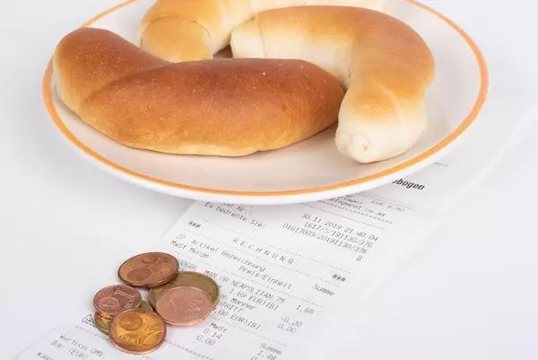Croissants with reciept and coins on white background