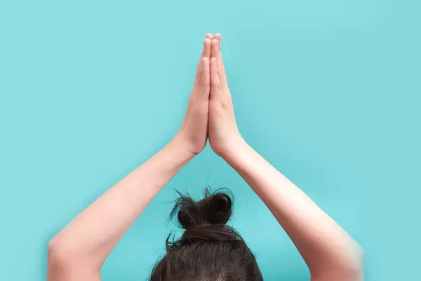 Cropped shot of a woman bringing the palms together