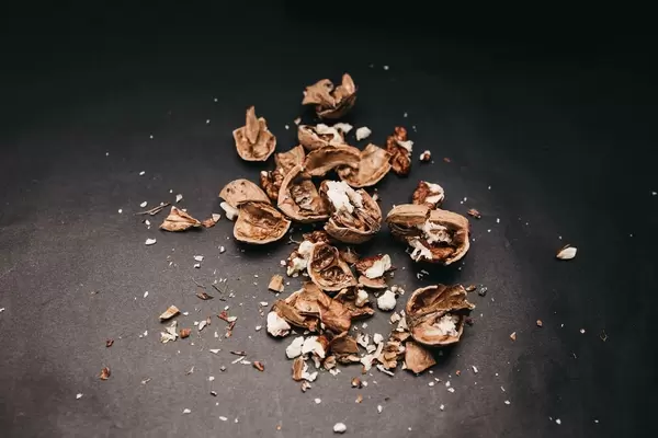 Crushed walnuts on black background.