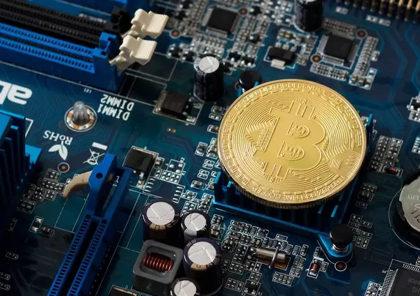 Cryptocurrency Bitcoin, golden coin on a blue pc mainboard