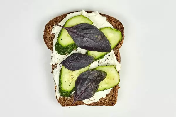 Cucumber slices, basil leaves with sour cream for snack