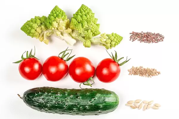 Cucumber, tomatoes, romanesco broccoli on a white background with seeds