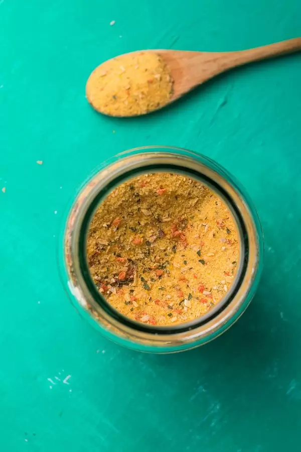 Culinary yellow sppice in a jar and on wooden spoon