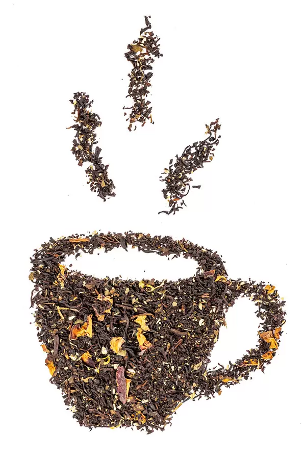 Cup made of dried tea with flower petals on white, top view