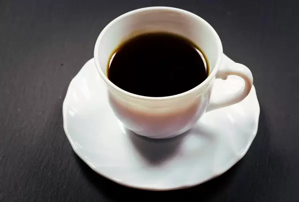 Cup of coffee against black background