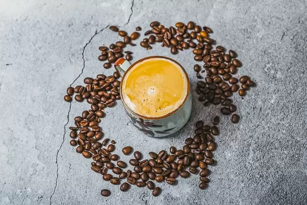 Cup of coffee surrounded by coffee beans. Top view.  (Flip 2019)