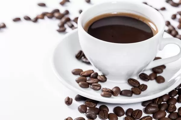 Cup of hot fresh coffee on a white background with grains