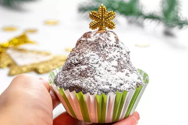Cupcake in a female hand on a Christmas background