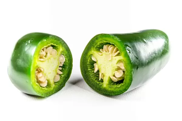 Cut fresh green jalapeno pepper on white background