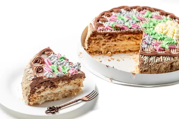 Cut piece on a plate traditional kiev cake with hazelnuts and meringue