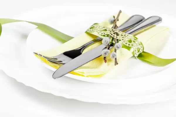 Cutlery on white plates with a napkin and ribbon