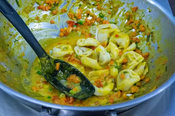 D´Angelo - Vegan Bio Cappelletti Nudeln mit Kürbis-Apfel Füllung werden in einer Soße mit Karotten und Paprika zubereitet