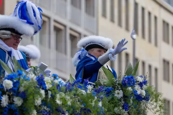 Dame in blau-weißer Uniform wirft Zuschauern Päckchen zu - Kölner Karneval 2018