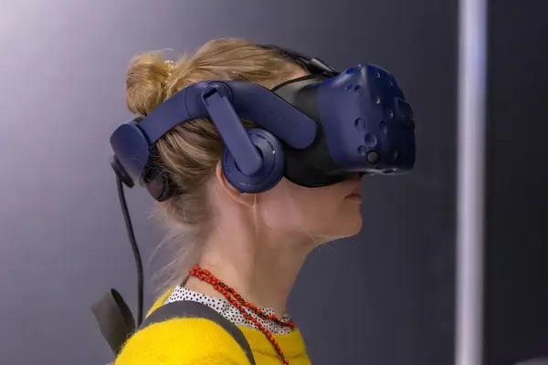 Dame mit gelbem Pullover testet die HTC Vive VR Brille an der Photokina in Köln