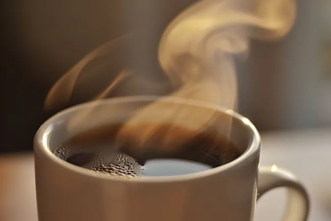 Dampfender Kaffee in einem Becher - Appetitanregendes Getränk