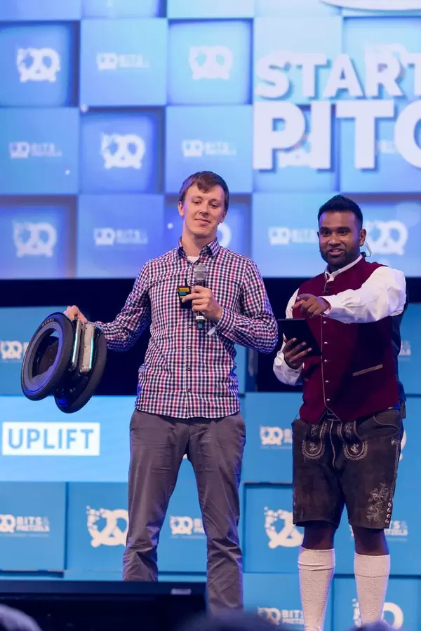 Dan Ram und junger Mann präsentieren eine Erfindung auf der Bühne