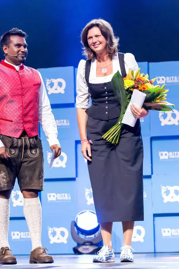 Daniel Ramamoorthy  überreicht Blumen an Ilse Aigner