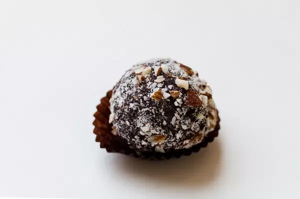 dark chocolate truffle with cocoa powder and chopped hazelnut